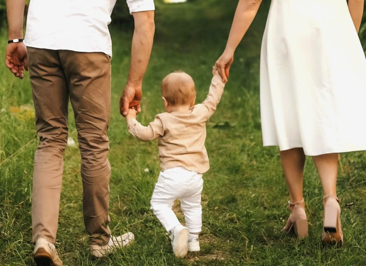 Parents walking hand-in-hand with their toddler